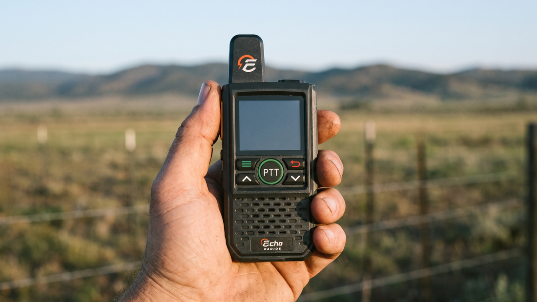A compact Echo radio held at chest height in one hand, front face toward the camera, with open rural country blurred behind.