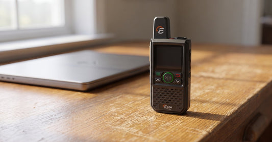 A compact Echo radio rests on a desk beside a closed laptop in morning light.